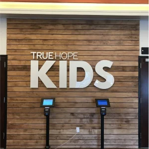 3D letter sign that says "True Hope Kids" installed in the interior of a church.