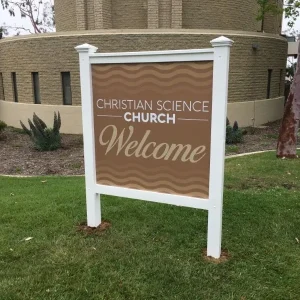 A post and panel sign that say "welcome" for chuch.
