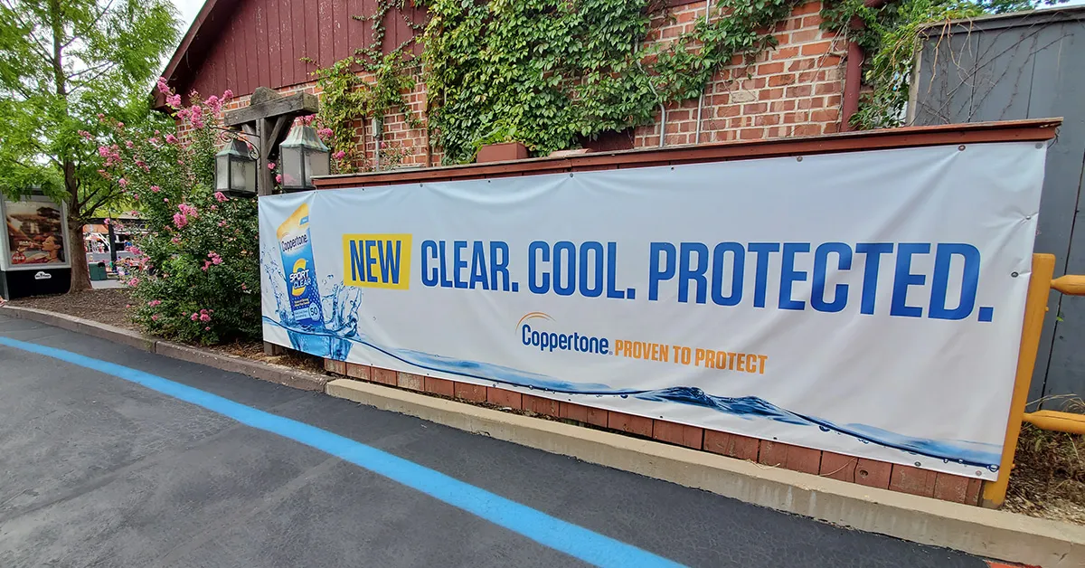 A large banner that advertises suncreen installed on a structure.