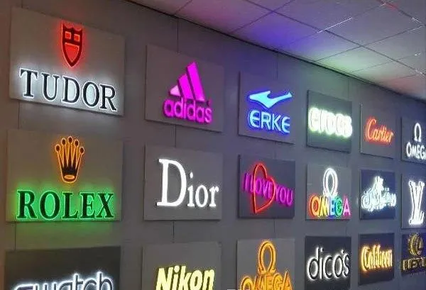 A wall of logo signs of various company logos, all lit up.